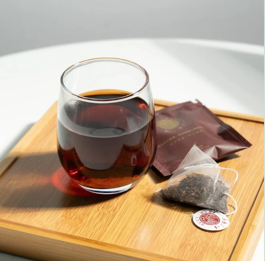 Ember Pouch Ripe Pu-erh Tea Sachet — Deep Red Liquor in Glass with Whole Leaf Triangular Tea Bag